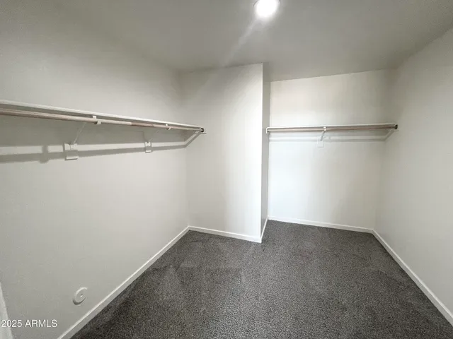 a spacious bedroom with a bed and glass window