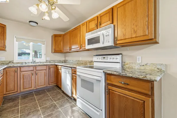 a kitchen with granite countertop stainless steel appliances a sink and cabinets