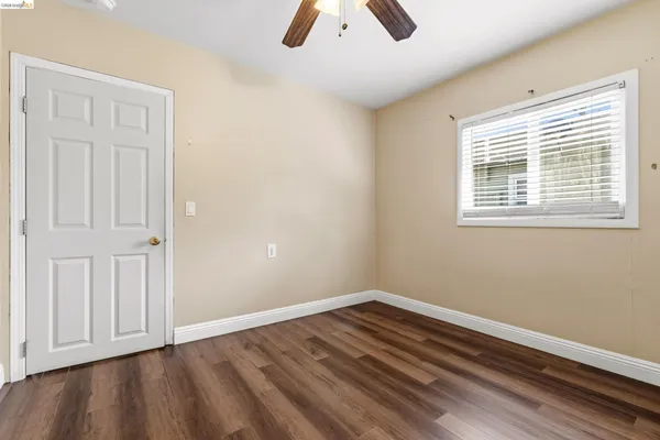 an empty room with a ceiling fan and carpet
