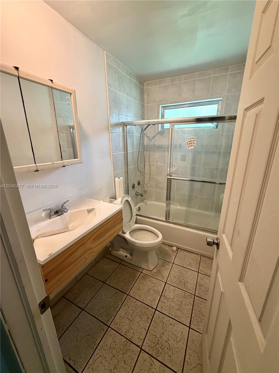9110 Southwest 44th Street Miami, FL 33165 - Photo 6 of 18 a bathroom with a granite countertop sink a toilet and shower