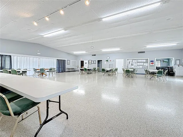 a room with lots of table chair and view of kitchen
