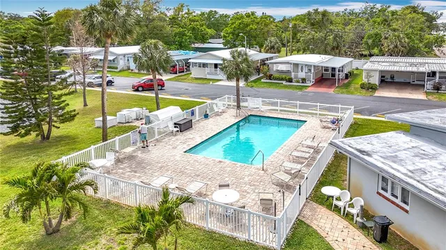 a view of a swimming pool with a patio and a yard