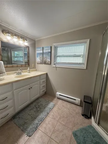 a room with a sink wooden floor and glass door shower