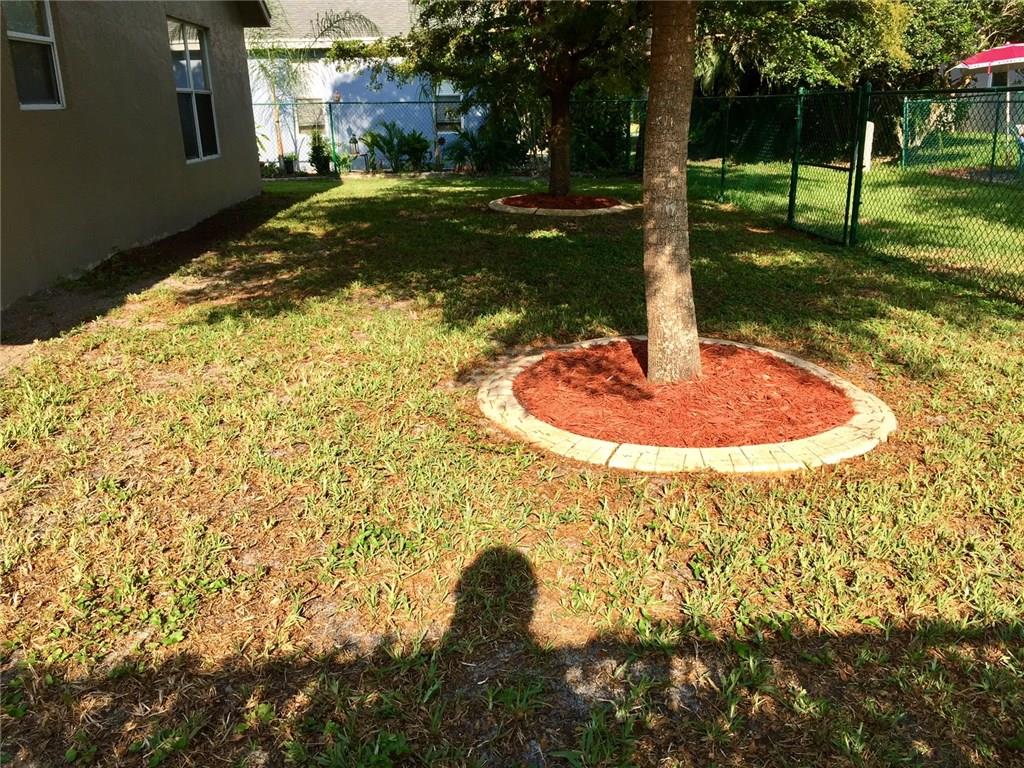 2498 Southwest Regency Road Stuart, FL 34997 - Photo 34 of 47 a backyard of a house with a yard and outdoor seating