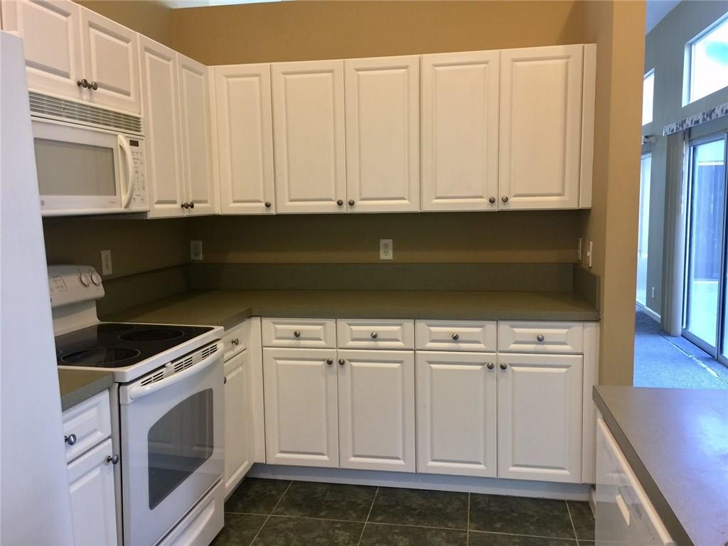 2498 Southwest Regency Road Stuart, FL 34997 - Photo 10 of 47 a kitchen with white cabinets and white appliances
