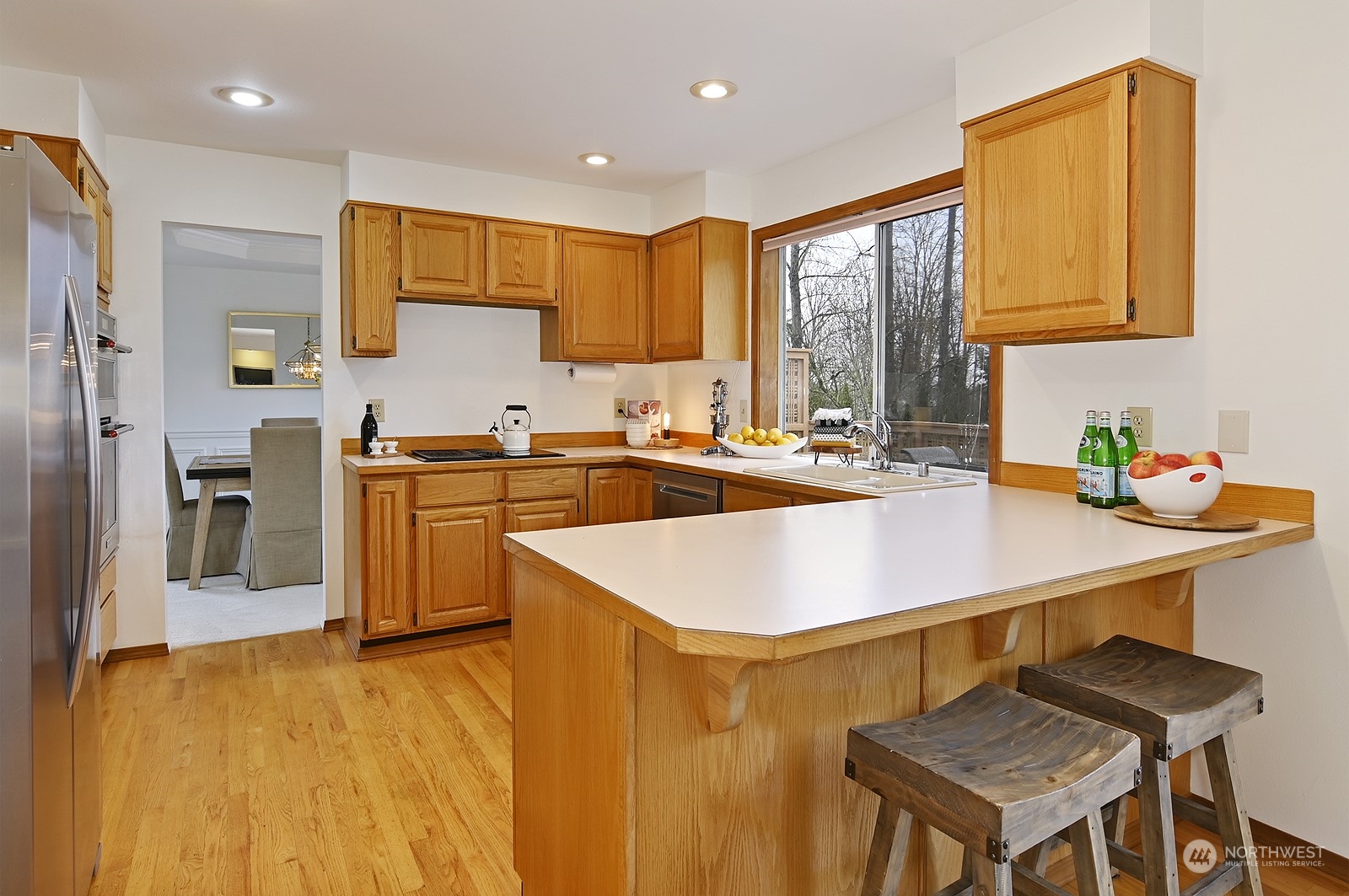 9117 Northeast 151st Street Bothell, WA 98011 - Photo 8 of 31 a kitchen with a sink a stove and chairs