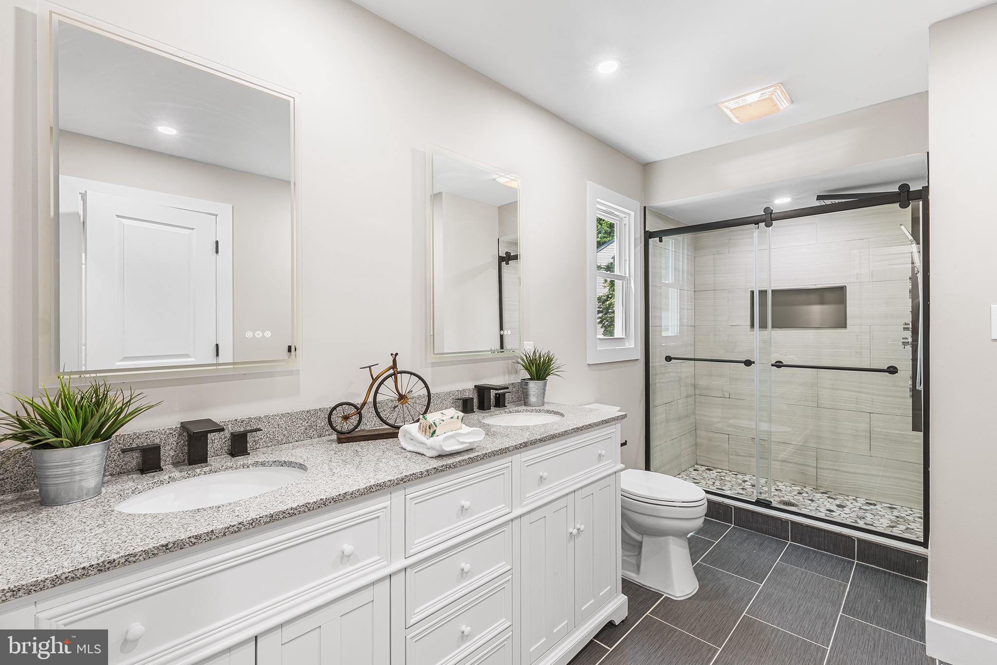 849 Glenn Circle Wayne, PA 19087 - Photo 17 of 36 a bathroom with a granite countertop sink mirror and toilet