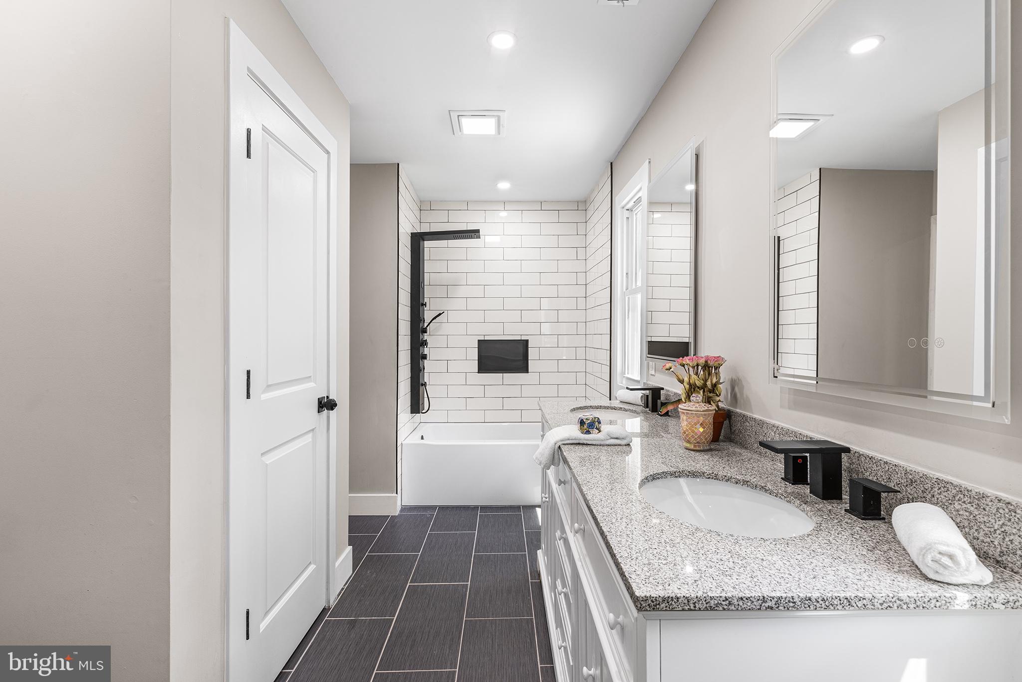 849 Glenn Circle Wayne, PA 19087 - Photo 27 of 36 a bathroom with sink granite tub shower and mirror