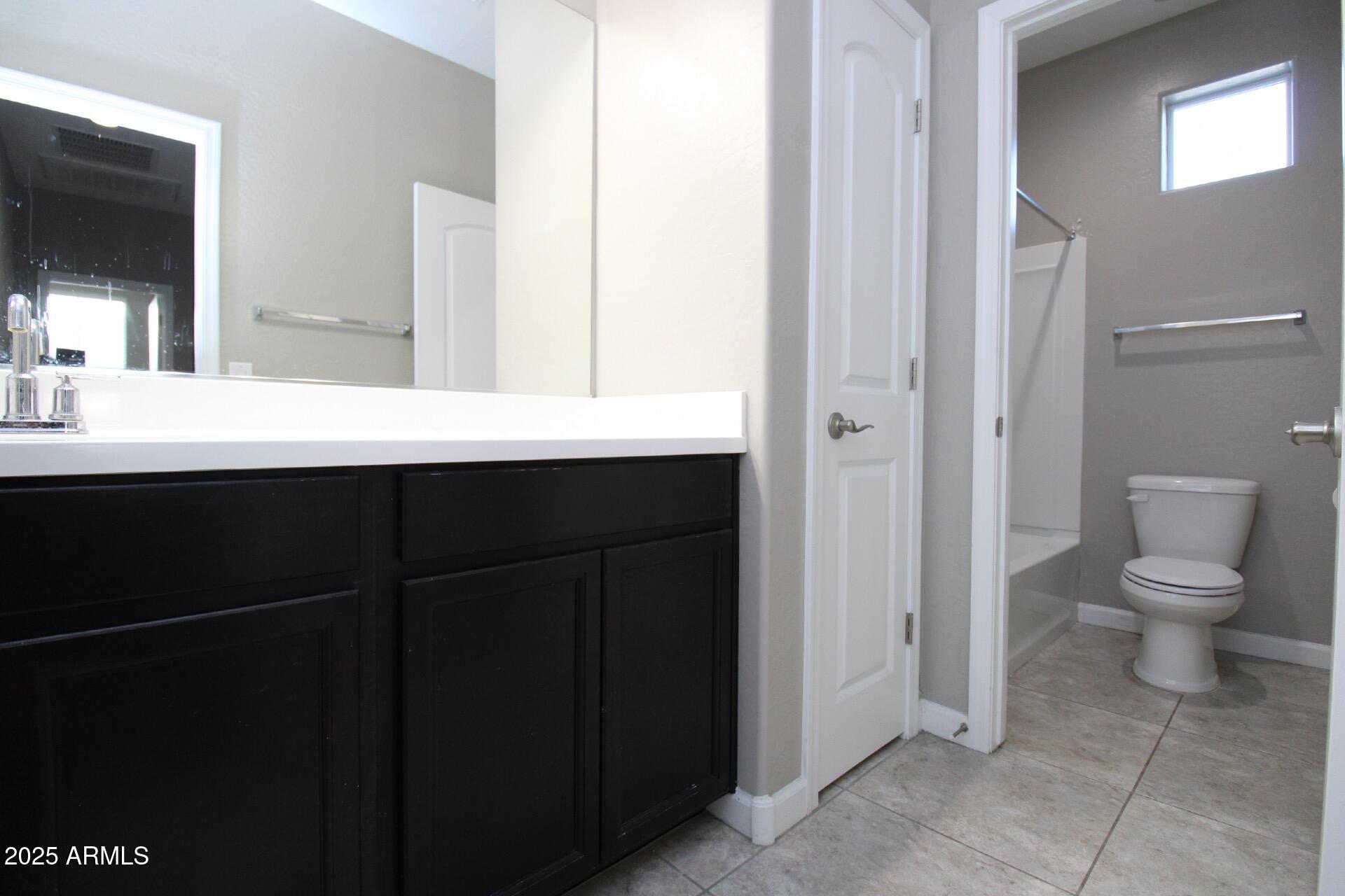 1255 North Arizona Avenue, Unit 1269 Chandler, AZ 85225 - Photo 13 of 29 a bathroom with a toilet sink and mirror