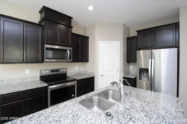 a kitchen with granite countertop wooden cabinets and stainless steel appliances