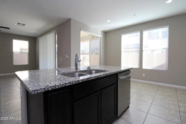a kitchen with a granite countertop sink stove and cabinets