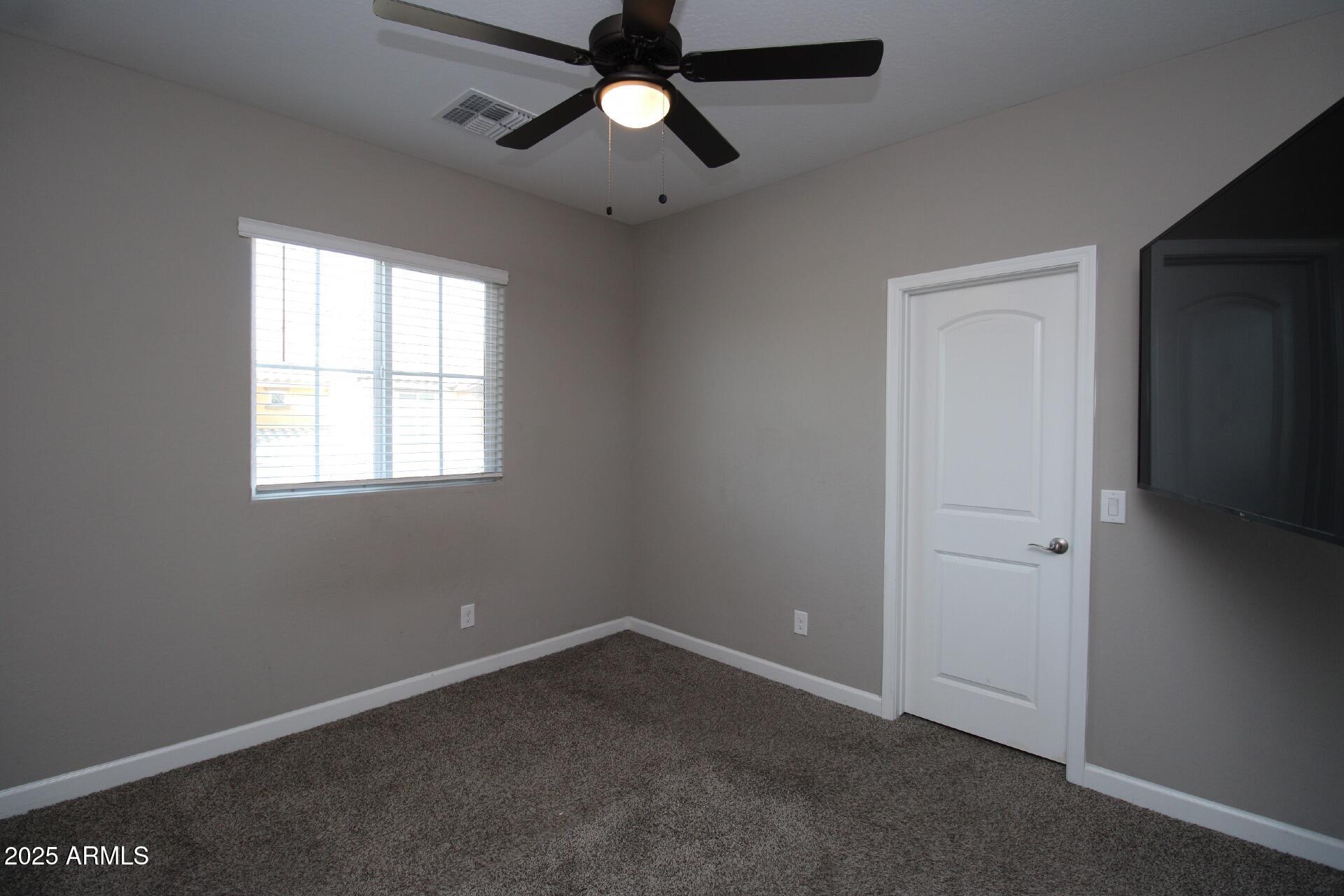 1255 North Arizona Avenue, Unit 1269 Chandler, AZ 85225 - Photo 10 of 29 an empty room with a window and a fan