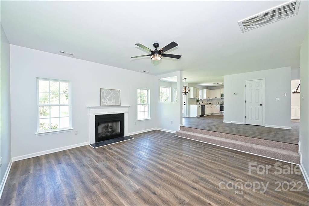 675 Winding Branch Road Rock Hill, SC 29732 - Photo 15 of 34 an empty room with windows fireplace and a kitchen view