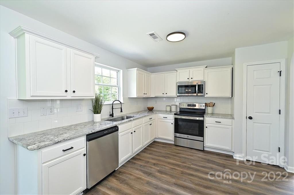 675 Winding Branch Road Rock Hill, SC 29732 - Photo 9 of 34 a kitchen with granite countertop white cabinets and white appliances