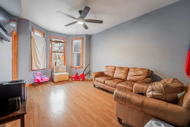 a living room with furniture flat screen tv and a large window