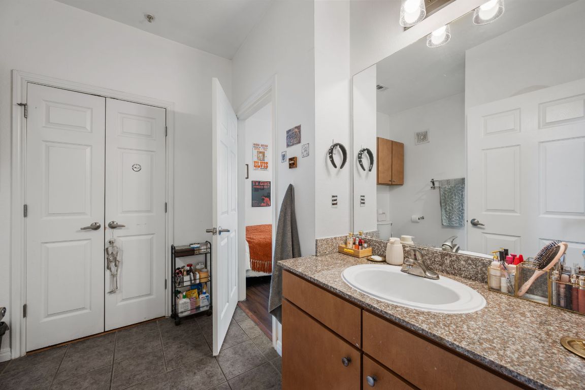 2502 Leon Street, Unit 511 Austin, TX 78705 - Photo 14 of 27 a bathroom with a granite countertop sink and a mirror