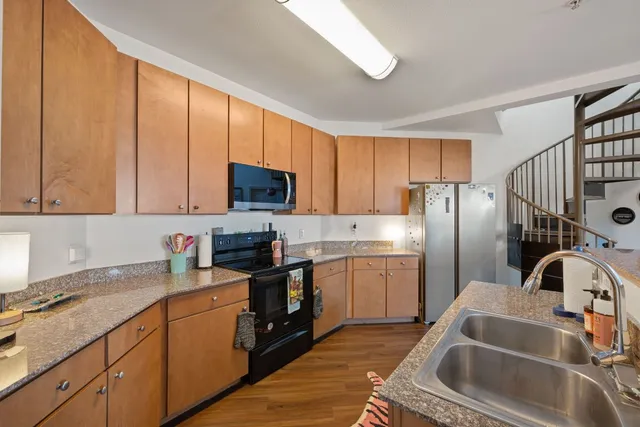a kitchen with a sink a refrigerator and cabinets