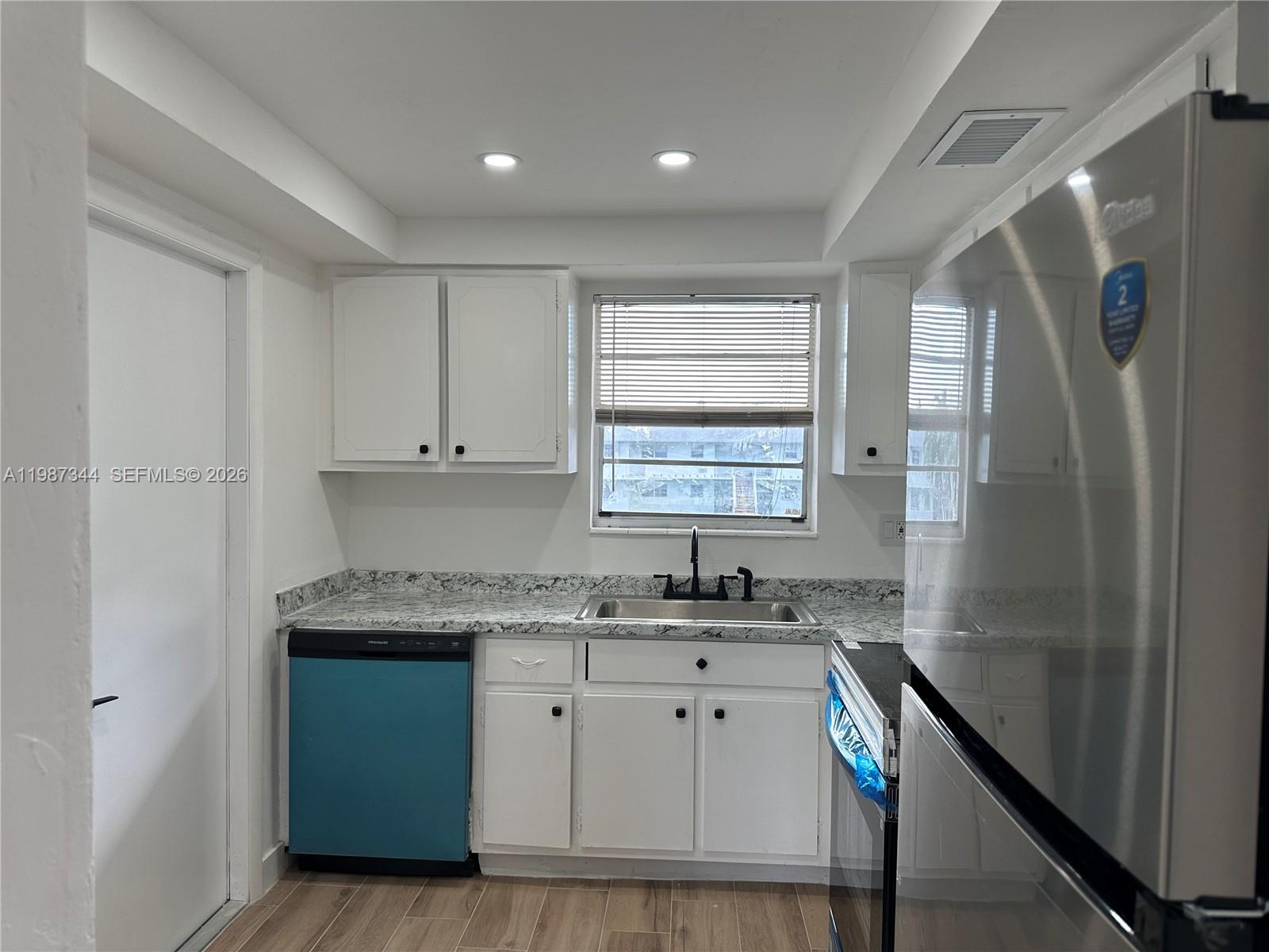 7670 Southwest 82nd Street, Unit H215 Miami, FL 33143 - Photo 3 of 9 a kitchen with stainless steel appliances granite countertop a sink stove and cabinets