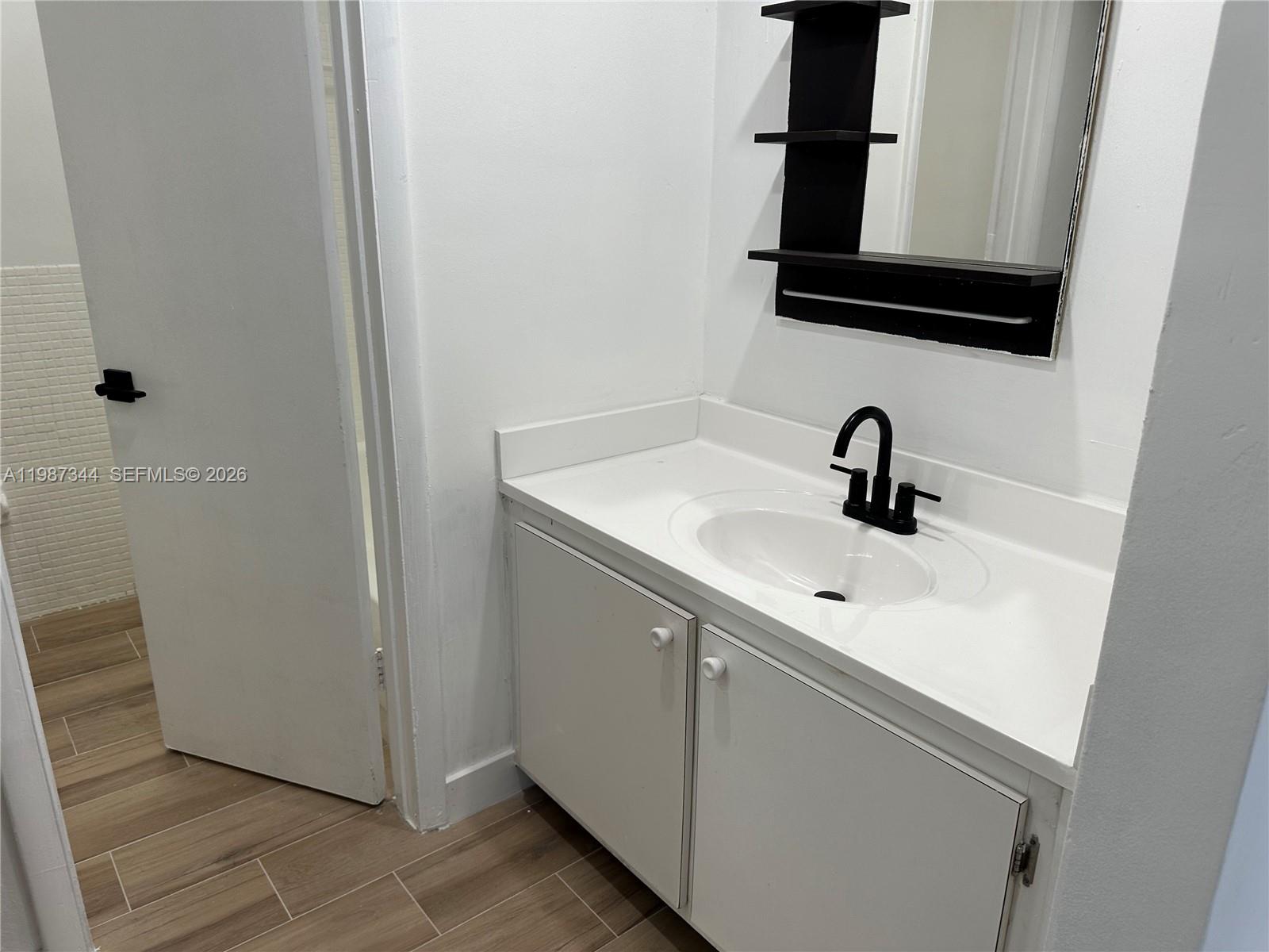 7670 Southwest 82nd Street, Unit H215 Miami, FL 33143 - Photo 6 of 9 a bathroom with a sink and a mirror