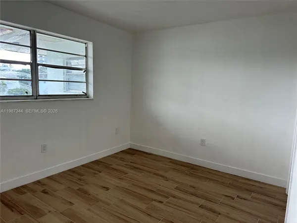 a room view with wooden floor and windows