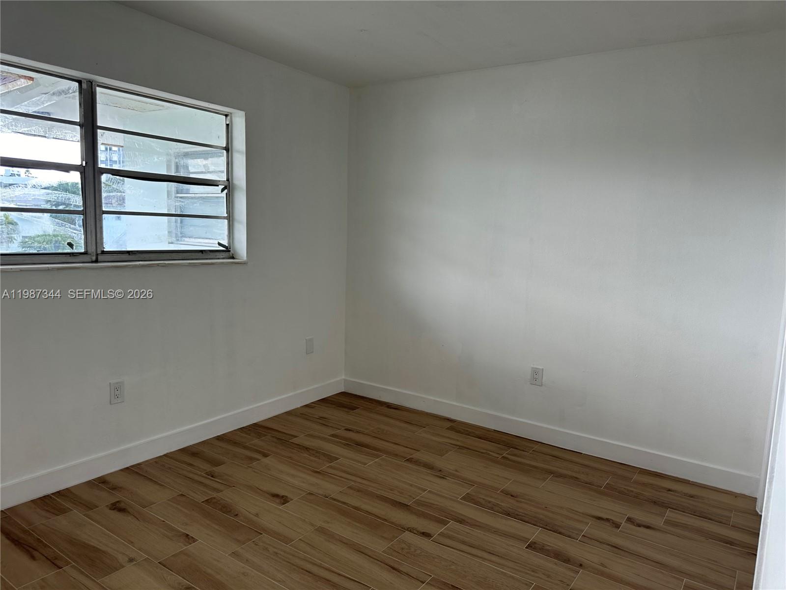 7670 Southwest 82nd Street, Unit H215 Miami, FL 33143 - Photo 8 of 9 a room view with wooden floor and windows
