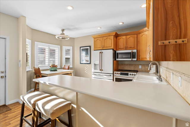 7824 South Sequoia Tree Lane Sandy, UT 84094 - Photo 10 of 43 Kitchen with high end white fridge, range with electric stovetop, light countertops, stainless steel microwave, and a peninsula