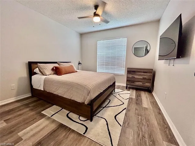 a bedroom with a bed a flat screen tv and dresser