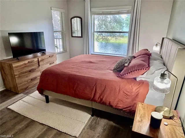 a bedroom with a large bed and a flat screen tv