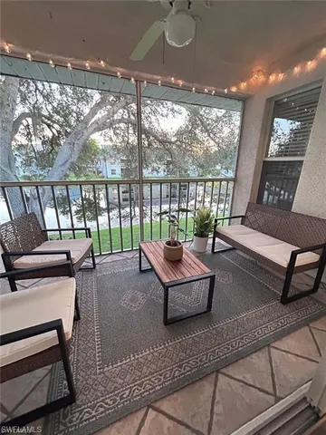 a living room with furniture and a floor to ceiling window