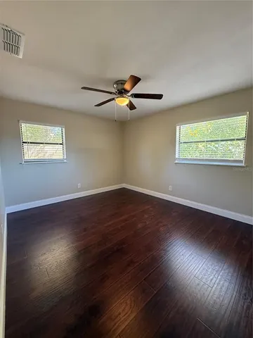 a view of room with wooden floor and fan