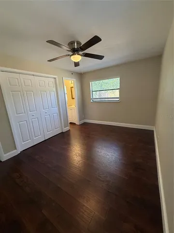 an empty room with wooden floor windows and entrance