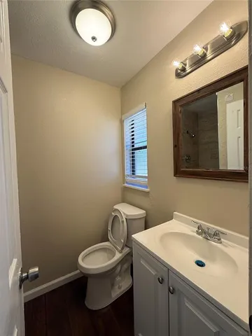 a bathroom with a toilet sink a mirror and vanity