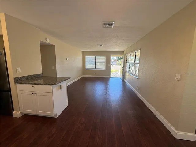 a hallway with white cabinets and wooden floor