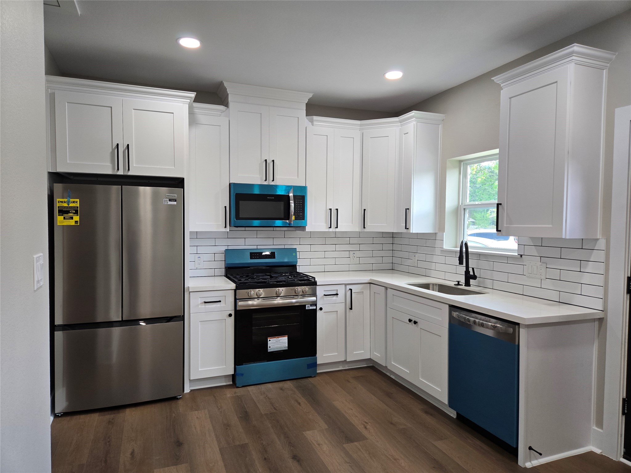 7830 Woodlyn Road, Unit B Houston, TX 77028 - Photo 2 of 10 Bright, modern kitchen with white shaker cabinets, new stainless appliances, and warm wood-tone flooring