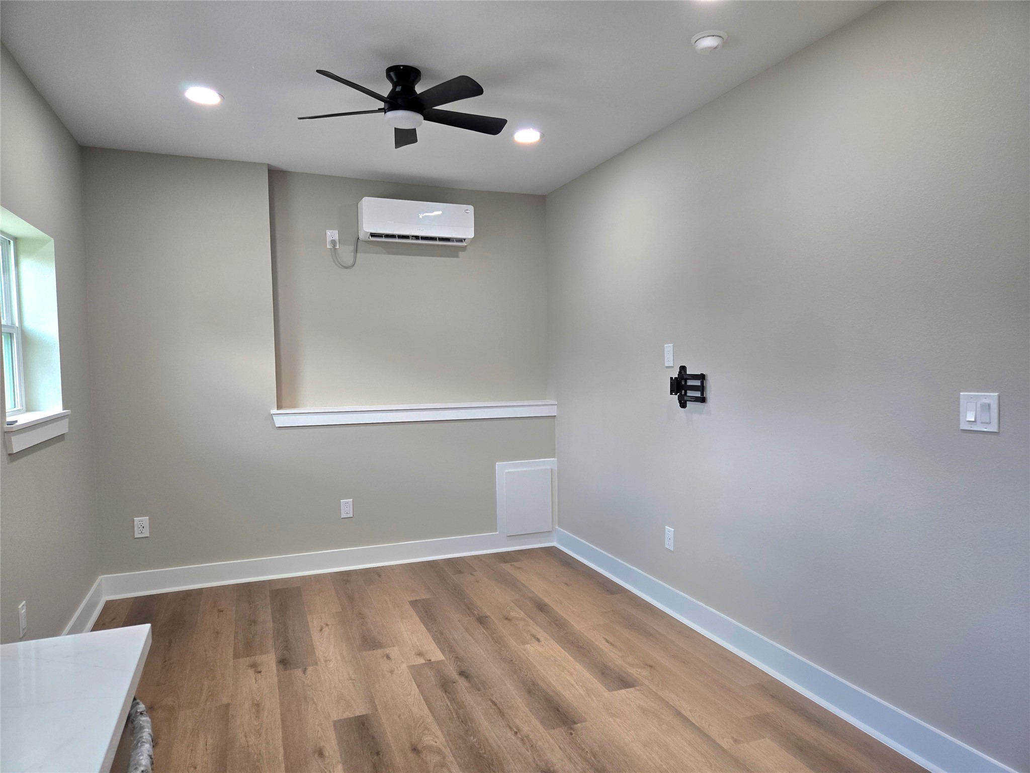 7830 Woodlyn Road, Unit B Houston, TX 77028 - Photo 4 of 10 Open living/dining area with wood-style flooring, recessed lighting, ceiling fan, and a mini-split for efficient comfort