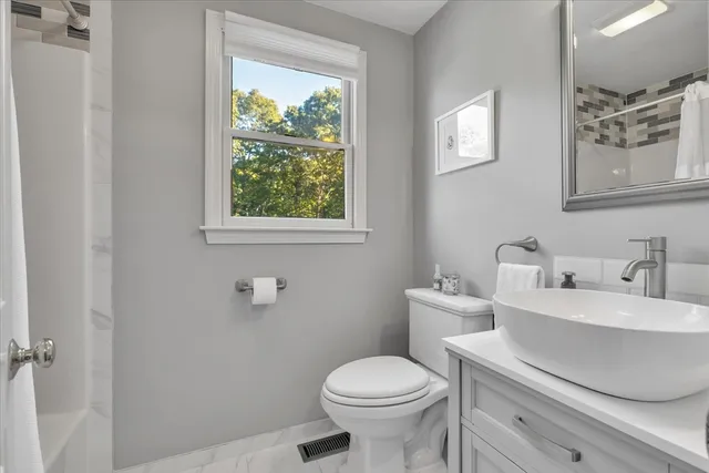 a bathroom with a toilet sink and mirror