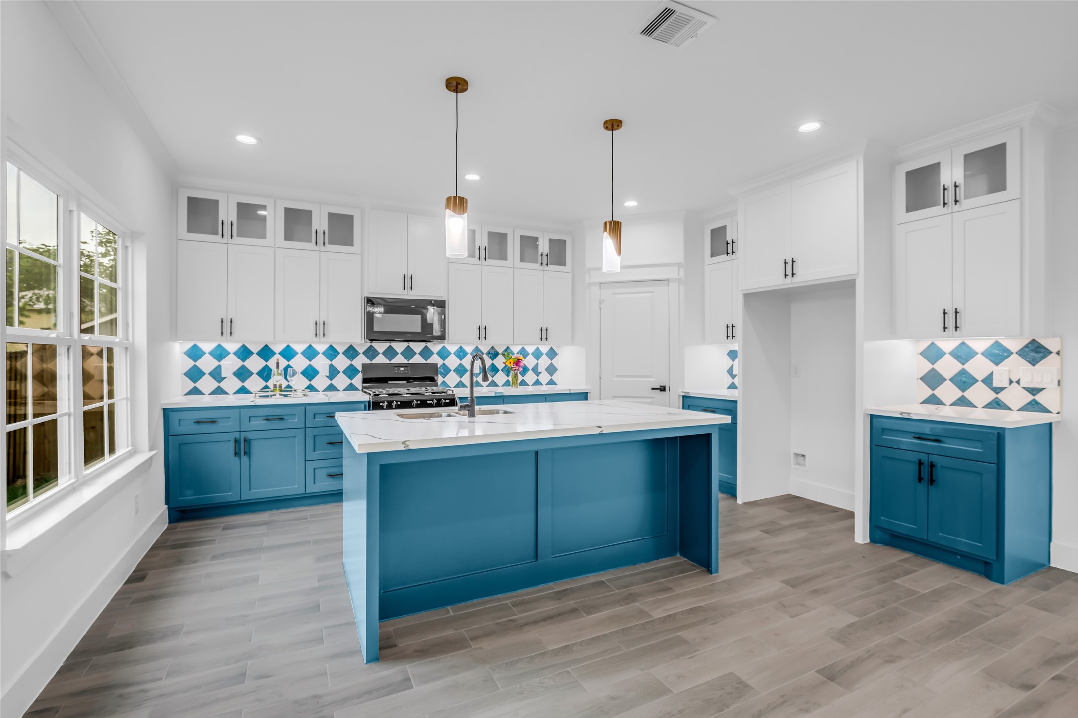 3168 Golfcrest Houston, TX 77087 - Photo 8 of 30 This kitchen and dining room blend modern elegance with a splash of color, featuring sleek cabinetry, eye-catching blue accents, and an inviting open layout perfect for entertaining.