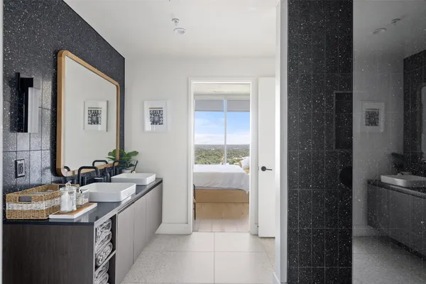 a bathroom with a double vanity sink a mirror and a bathtub