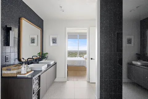 a bathroom with a double vanity sink a mirror and a bathtub