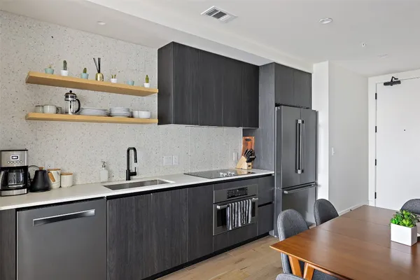 a kitchen with stainless steel appliances a sink cabinets and refrigerator