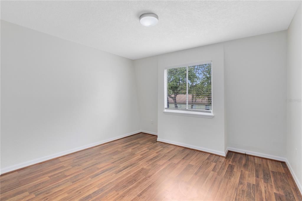 1938 South Conway Road, Unit 5 Orlando, FL 32812 - Photo 13 of 21 an empty room with wooden floor and windows