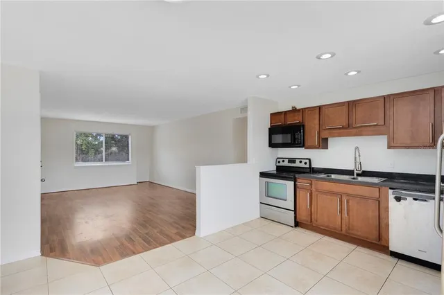 a kitchen with stainless steel appliances granite countertop a refrigerator and a stove top oven