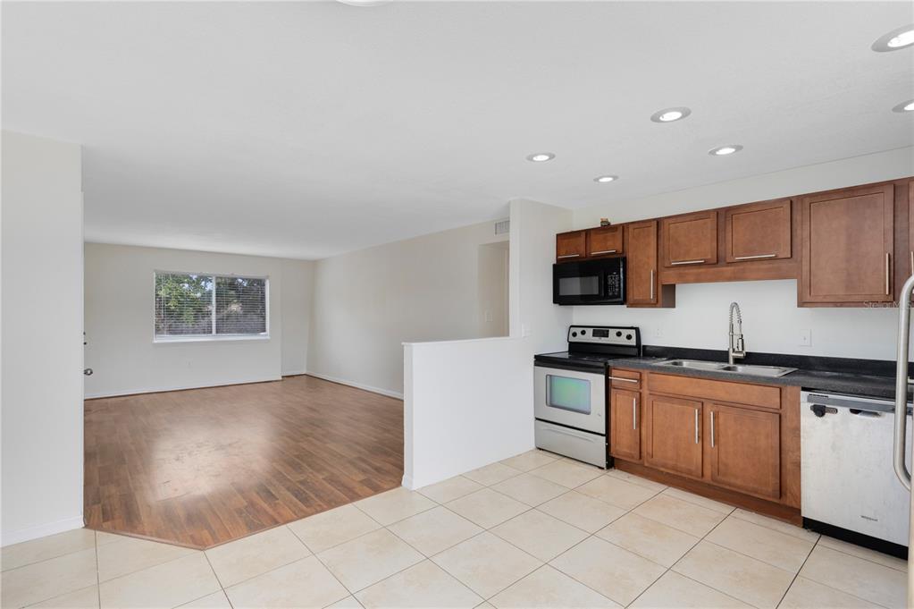 1938 South Conway Road, Unit 5 Orlando, FL 32812 - Photo 5 of 21 a kitchen with stainless steel appliances granite countertop a refrigerator and a stove top oven
