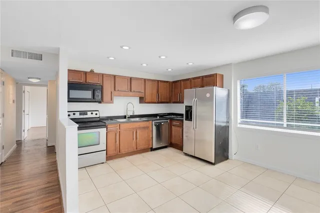 a kitchen with a refrigerator and a stove top oven
