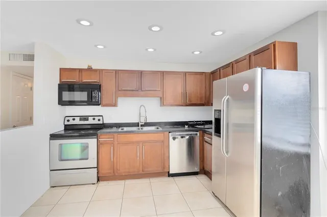 a kitchen with stainless steel appliances granite countertop a refrigerator stove and sink
