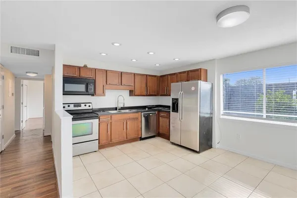 a kitchen with a refrigerator and a stove top oven
