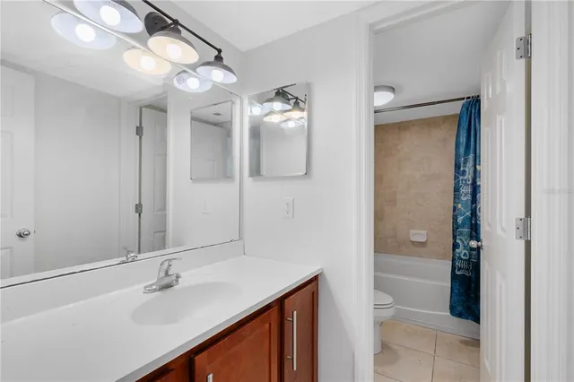 a bathroom with a sink vanity granite tub and shower