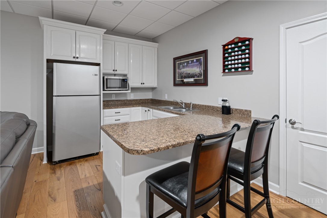 147 Riverside Park Court, Unit G2 Jefferson, NC 28640 - Photo 29 of 44 a kitchen with granite countertop a refrigerator a stove a microwave and a dining table
