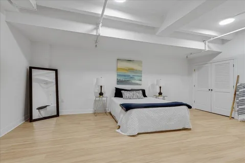 a bedroom with a bed and painting on the wall