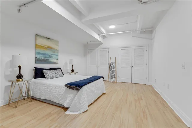 a spacious bedroom with a bed and a painting on the wall